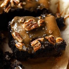 chocolate cake with pecans and caramel drizzled on top, ready to be eaten