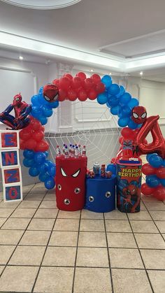 the balloon arch is decorated with spiderman balloons and other decorations for a birthday party