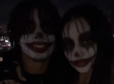 two people with painted faces posing for the camera