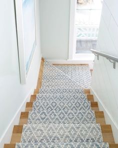 a white and blue rug is on the stairs