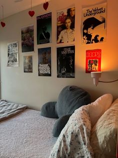 a bedroom with posters on the wall above the bed