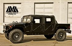 a black jeep is parked in front of a building with two doors on the side