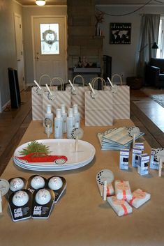 the table is set up for a party with candles, candy and gift bags on it