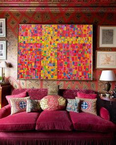 a living room with pink couches and paintings on the wall above them, along with two lamps