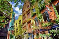 an alleyway with lots of colorful buildings and plants growing on the side of it