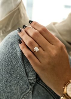 a woman's hand with a ring on her finger and a watch in the other hand