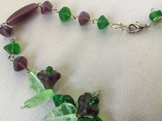 "Beautiful shade of frosted light and dark green art glass leaves with purple glass bell shaped flower and green accent beads. Incised spearmint leaf design of varying sizes show veining accents and are intertwined with the sweet flowers to form a vine. A lovely cluster at the base of the necklace forms a beautiful bib. This strand could become one of your favorites. Necklace is 18\" long at longest. The beads are in good condition and the colors are amazing. Lovely, romantic, delicate look. Ple Dark Green Art, Sweet Flowers, Bone Necklace, Purple Art, Bone Beads, Green Art, Green Accents, Necklace Choker, Purple Glass