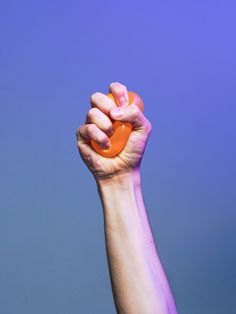 a hand holding an orange object up in the air