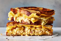 two grilled sandwiches stacked on top of each other with cheese and meat in between