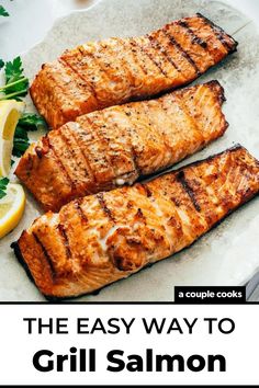 grilled salmon on a plate with lemon wedges and parsley in the background