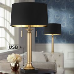 two lamps on a table in front of a couch with the labeled usb below it