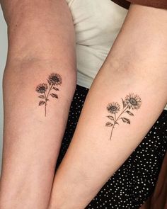 two women with matching tattoos on their arms, one has a sunflower and the other has a flower