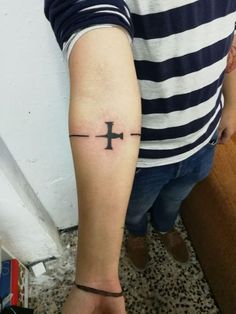 a person with a cross tattoo on their arm