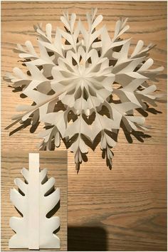 a white paper snowflake sitting on top of a wooden table