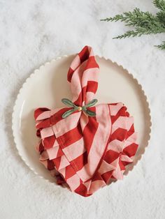 red and white checkered napkins on a plate next to a pine tree branch