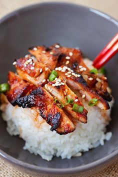 chicken and rice in a bowl with chopsticks