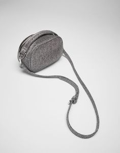 a small gray purse sitting on top of a white table