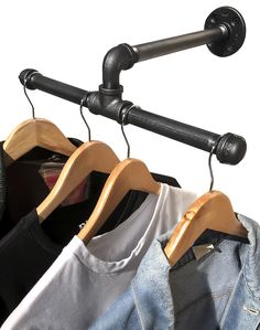 three wooden hangers holding shirts and jeans