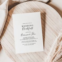 the wedding breakfast program is on top of a wooden platter with white linens