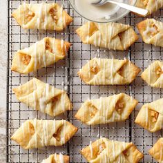 several pastries on a cooling rack next to a bowl of yogurt and spoon