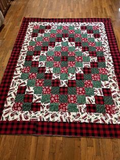 a red and green christmas quilt on the floor