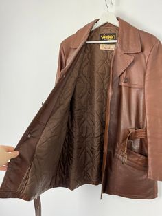 Vintage genuine leather brown pocketed belted jacket, long sleeves, button up closure. Brand: Vinson Made in Sweden  Size on tag: 100 Material: genuine leather  Would fit sizes s, m, l - depending on desired fit Measured laying flat: 31 1/2", 80 cm long 23", 58.5 cm armpit to armpit 18 3/4", 47.5 cm shoulders seam to seam 23 1/2", 59.5 cm sleeve length Some colour spots at the right side of jacket's bottom, please see photos, otherwise great vintage condition. If you have any questions, please let me know, I will be happy to answer! Best wishes, Juta Brown Belted Leather Jacket With Long Sleeves, Vintage Brown Single-breasted Leather Jacket, Vintage Brown Leather Jacket, Cooling Scarf, Belted Jacket, Jacket Long, Brown Leather Jacket, 80s Vintage, Vintage Brown