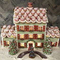 a gingerbread house decorated for christmas with candy on the roof and decorations around it