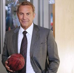 a man in a suit and tie holding a basketball