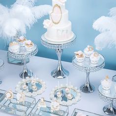 a table topped with cakes and cupcakes covered in white frosted icing