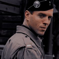 a man in uniform is looking at the camera with an evil look on his face