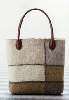 a handbag made out of wool with leather handles and two different color blocks on the front