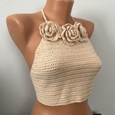 a mannequin wearing a crocheted halter top with flowers on it