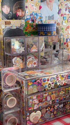 the drawers are filled with many different types of buttons and magnets on display in front of a wall