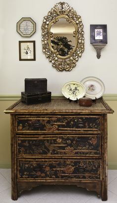 there is a dresser with plates on it in front of a mirror and other decorations