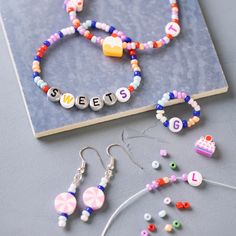 beads, bracelets and earring sets on a table next to a binder