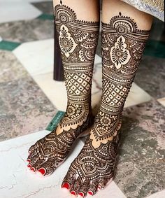 the legs and feet of a woman with henna tattoos