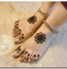 two women with henna tattoos on their feet