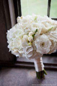 a bouquet of white flowers sitting on top of a window sill