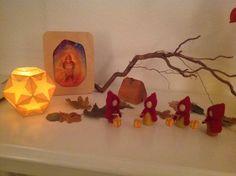 an assortment of items displayed on a mantle with candles and paper decorations in the foreground