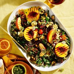 a salad with grilled peaches, onions and other vegetables in a white bowl