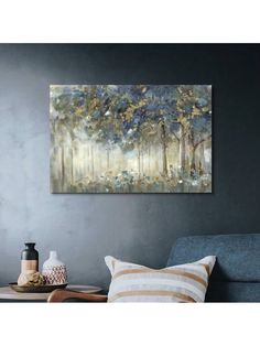 a painting hanging on the wall above a couch in a room with grey walls and pillows