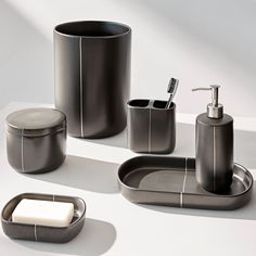 an assortment of bathroom accessories including soap dispenser, toothbrush holder and soap dish