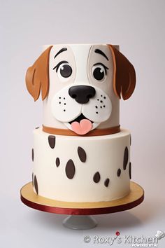 a cake decorated with a dog's face and polka dots on the bottom tier