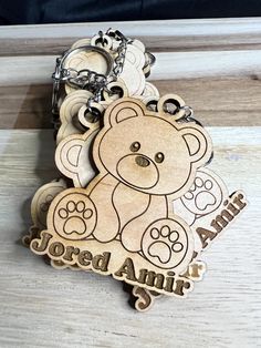 a wooden keychain with a teddy bear on it's front and back