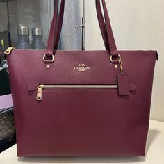 Crossgrain Leather Inside Zip, Cell Phone And Multifunction Pockets Zip-Top Closure, Fabric Lining Handles With 10 1/4" Drop Outside Zip Pocket 12 3/4" (L) X 10 1/2" (H) X 5 1/2" (W) Style No. 79608 Burgundy Bag With Branded Hardware, Coach Burgundy Bag With Zipper Closure, Burgundy Bags With Zipper Pocket, Elegant Coach Shoulder Bag With Zipper Pocket, Coach Bags With Zipper Pocket For Shopping, Coach Gallery Tote, Bags Coach, Black Cherry, Zip Top