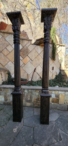 two tall black pillars sitting on top of a stone walkway