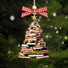 an ornament shaped like a christmas tree with books stacked on it and a bow hanging from the top