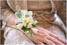 an older woman's hand holding a bouquet of flowers