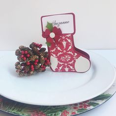 a white plate topped with a christmas stocking and pine cones