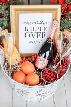 a holiday gift basket filled with champagne, oranges and other christmas decorations next to a sign